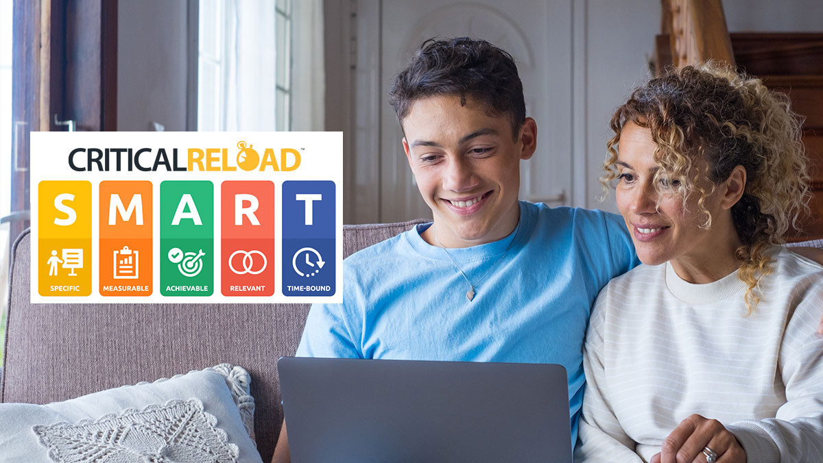 a mother andher son sitting on a coach reviewing smart method goals on a laptop