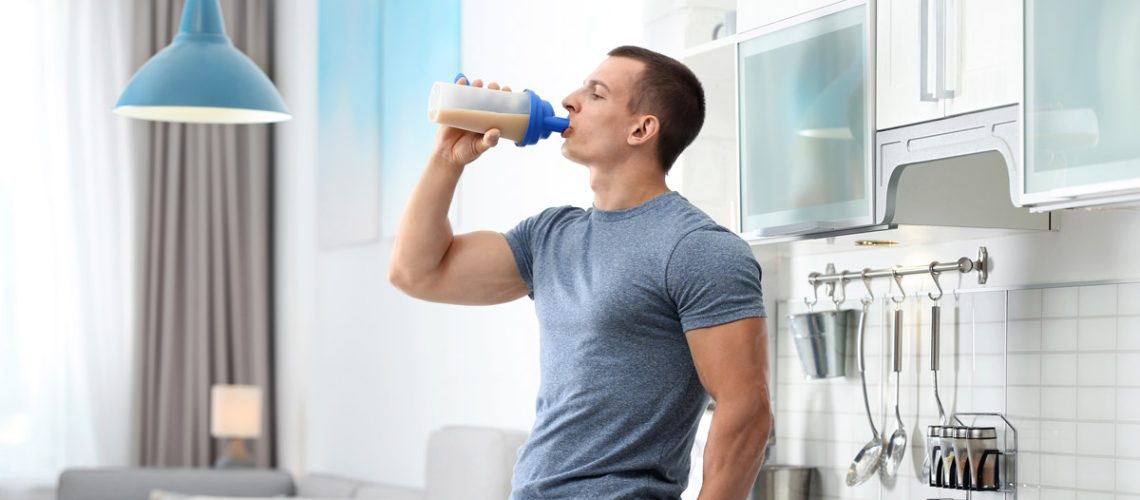 Man having a pre- or post-exercise protein supplement.
